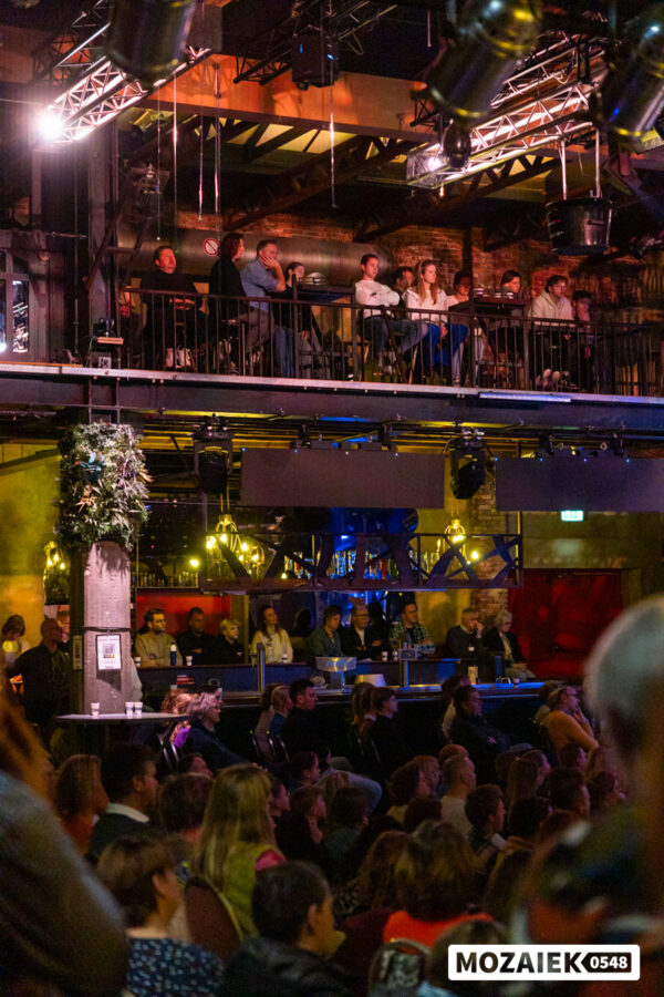 Bezoekers kijken vanaf het balkon en vanuit de zaal mee tijdens een dienst van Mozaiek0548
