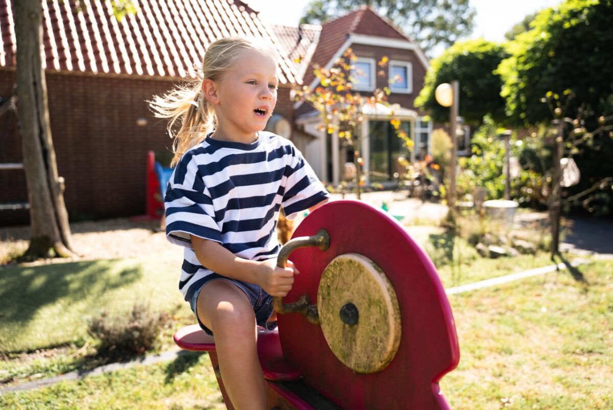 Meisje speelt op een speeltoestel in de tuin tijdens de Kidsdag van Mozaiek0548