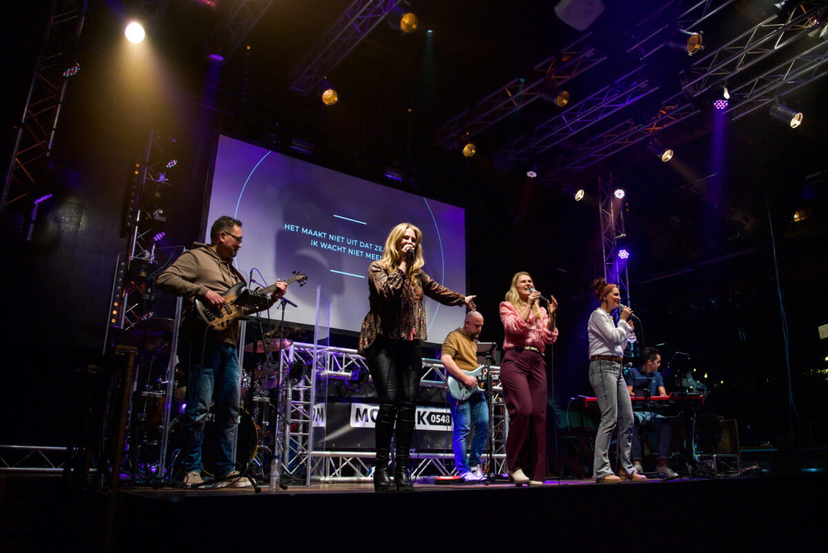 Zangeres en band spelen op het podium tijdens de worship